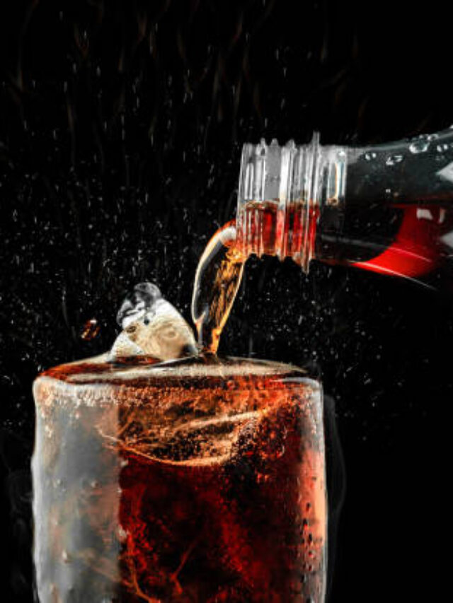 Pour soft drink in glass with ice splash on dark background.